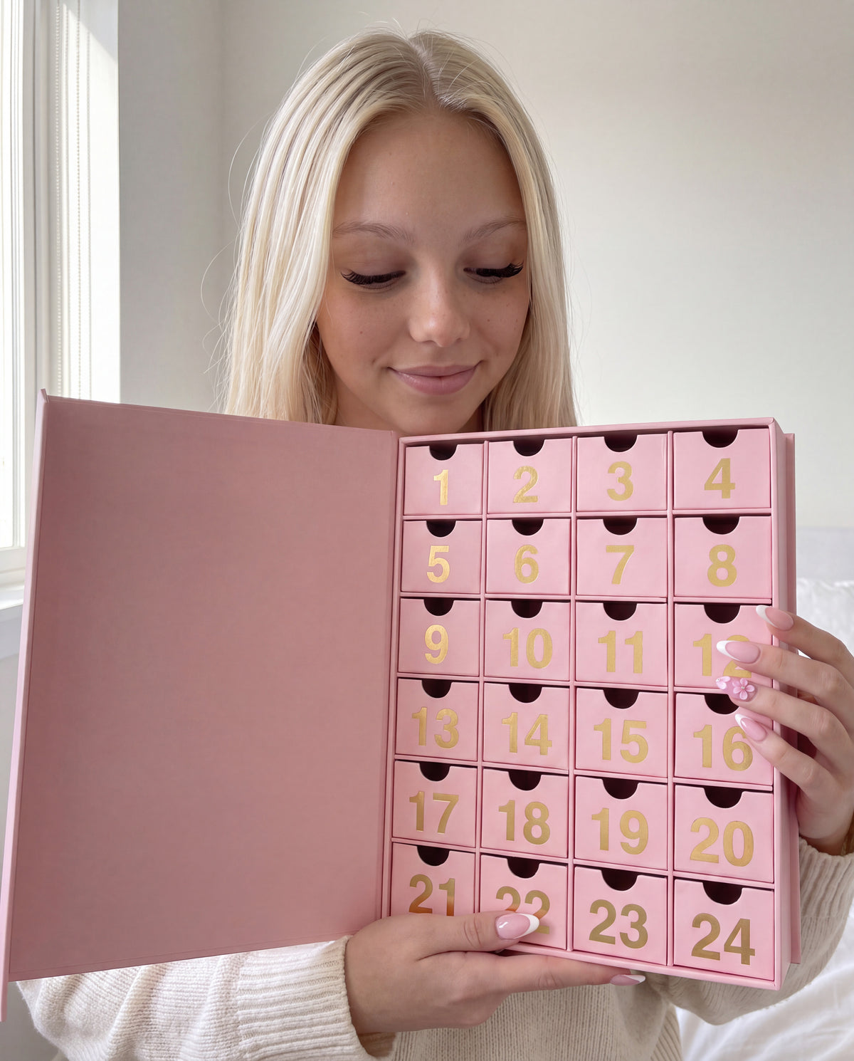 24 cases — Lily regarde les tiroirs du calendrier de l'Avent bijoux ouvert.