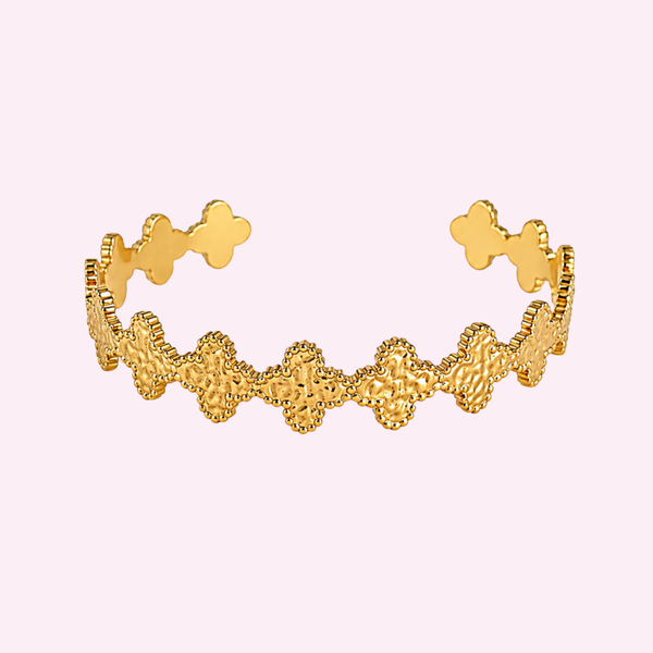 Bracelet Leeyah doré ouvert à motif de trèfles, acier inoxydable, fond rose pâle