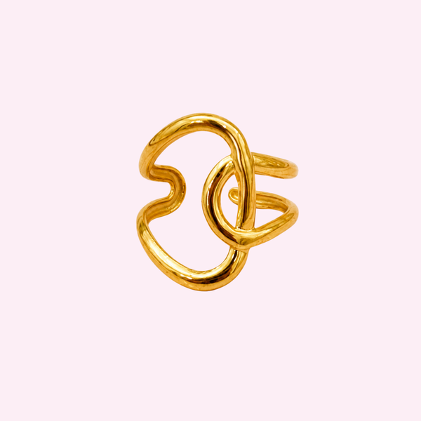 Bague Elisa dorée ajustable en acier inoxydable, design abstrait, fond rose pâle