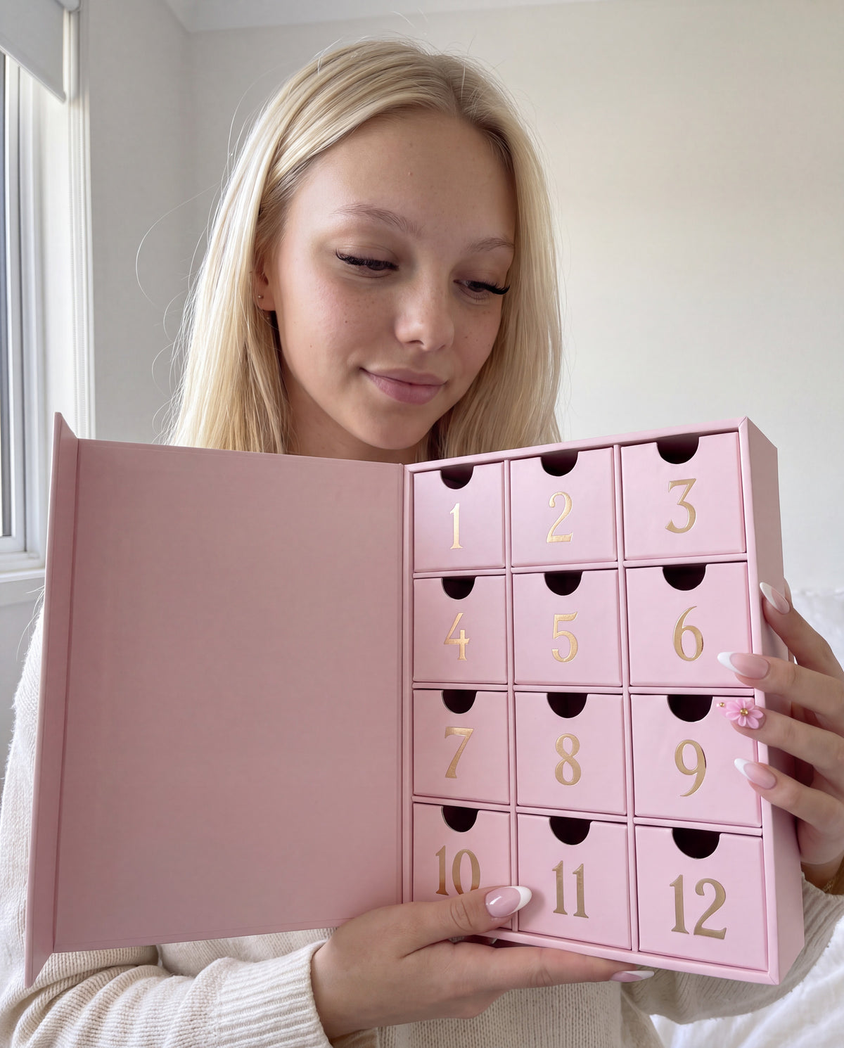 Lily avec le calendrier de l'Avent 12 cases ouvert devant elle.